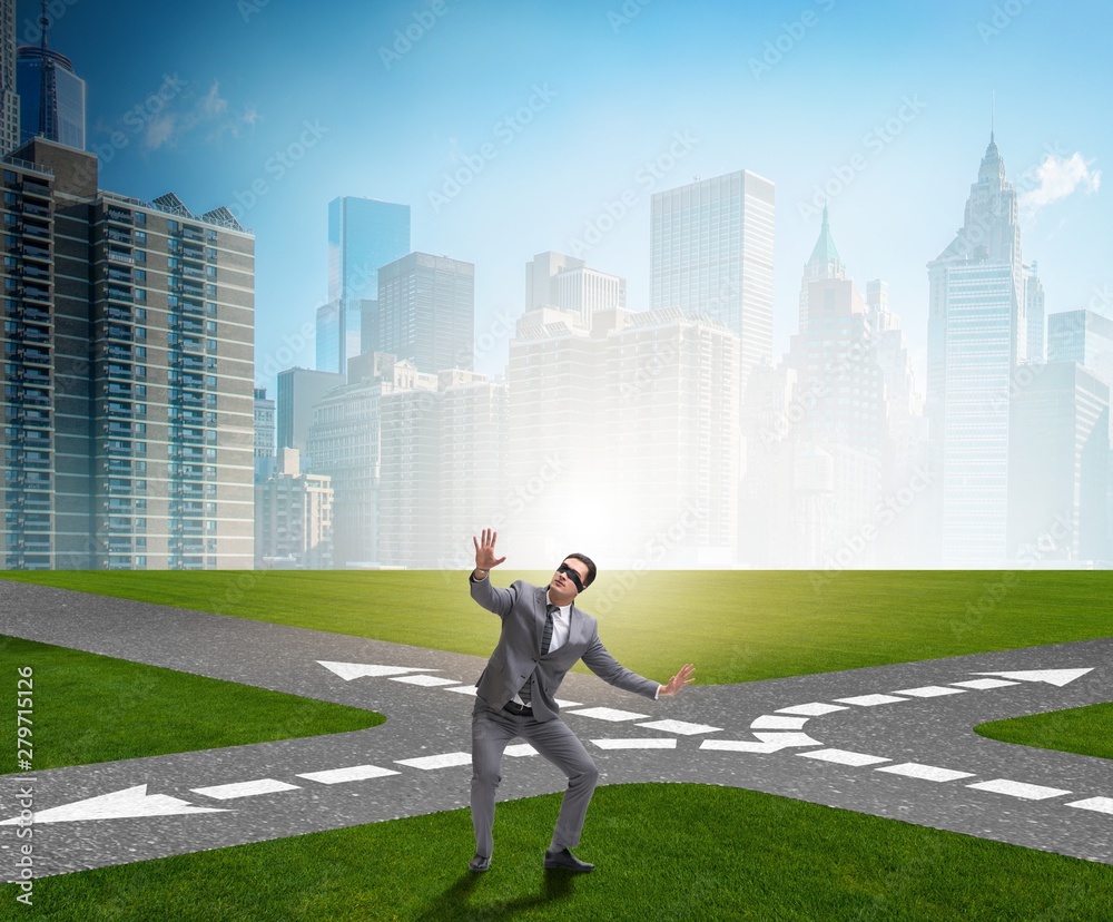 Young businessman at crossroads in uncertainty concept