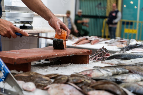 Fish monger cutting salmon at the market
