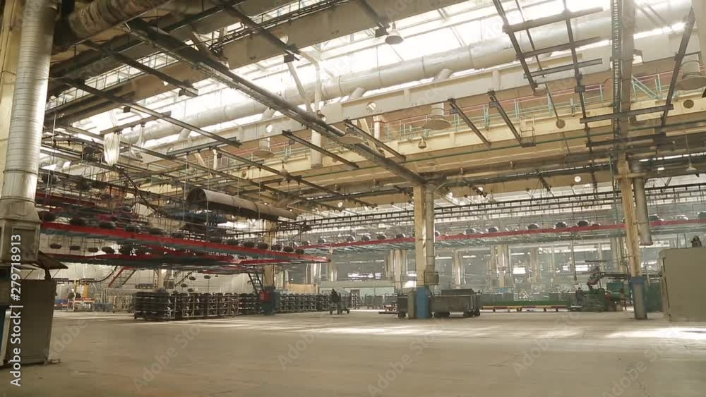 Manufacture of automobile tyres. Large car tire factory. Conveyor with tires at factory. Tires production. Air conveyor transfers tire from one operation to others above processing work shop. Manufacture of automobile tyres. Large car tire factory. Conveyor with tires at factory. Tires production. Air conveyor transfers tire from one operation to others above processing work shop.