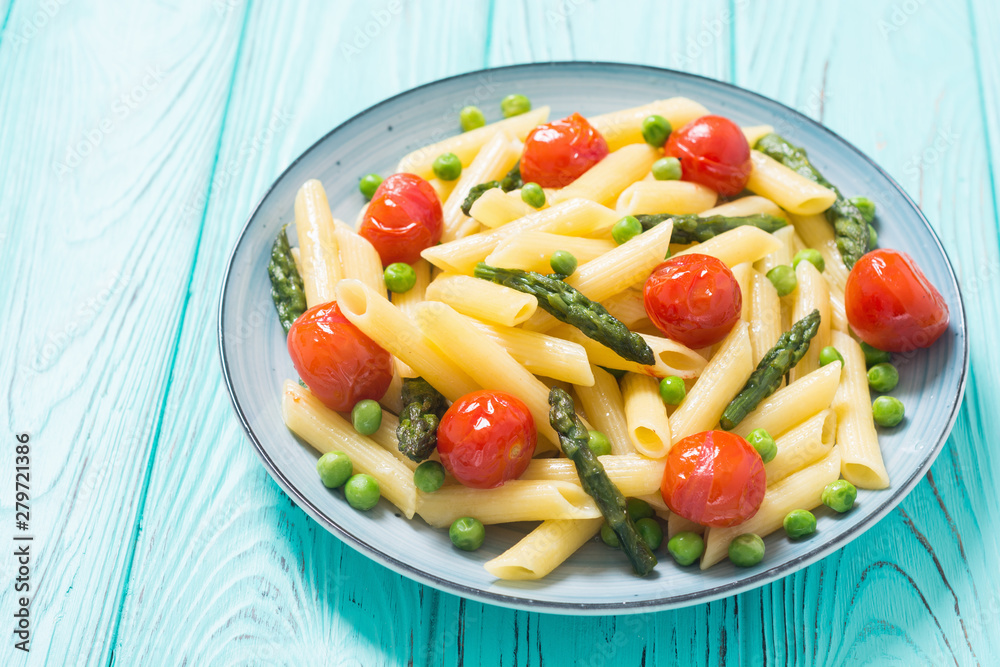 Penne pasta salad with asparagus , tomatoes and peas