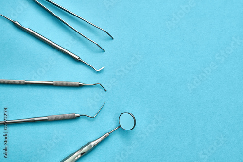 Kit of dental instruments lying on blue surface