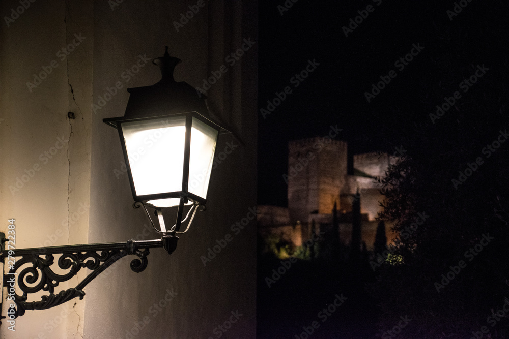 A street light in Granada Spain with the Alhambra in the backgound