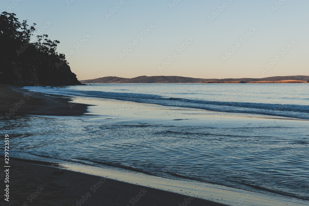 Obraz premium view of the water on a Tasmanian beach in South Hobart at dusk