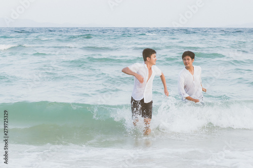 Homosexual portrait young asian couple running with cheerful together on beach in summer, asia gay going tourism for leisure and relax with happiness in vacation at sea, LGBT legal concept. © N_studio