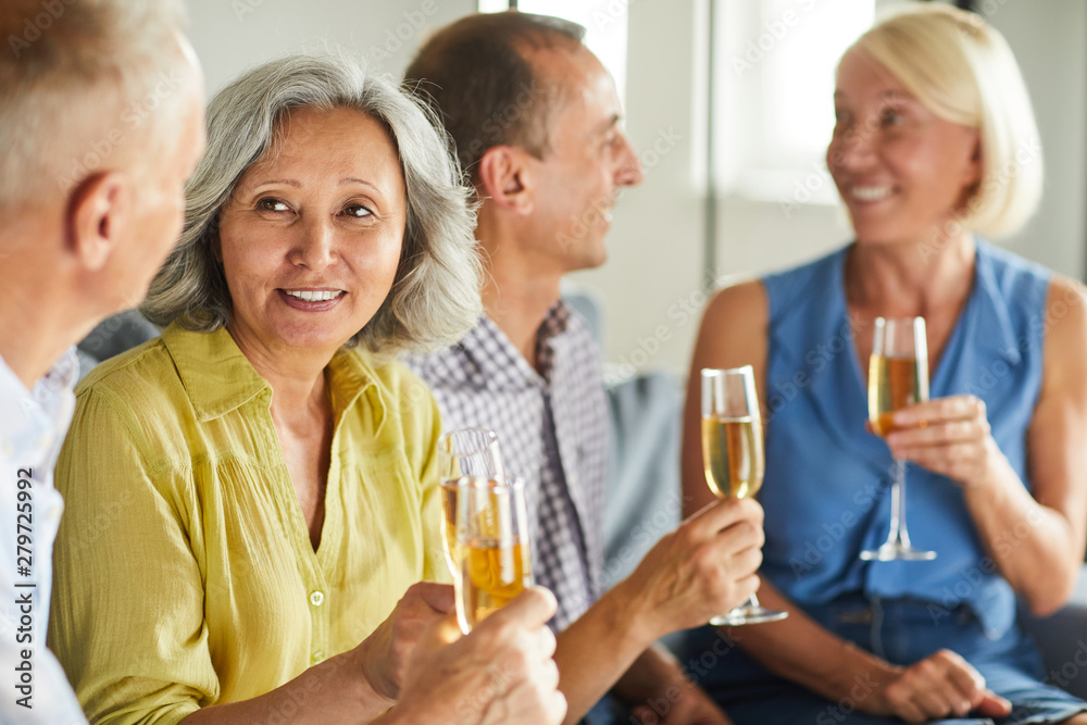 Group of modern senior people drinking champagne while enjoying party at home, copy space Group of modern senior people drinking champagne while enjoying party at home, copy space