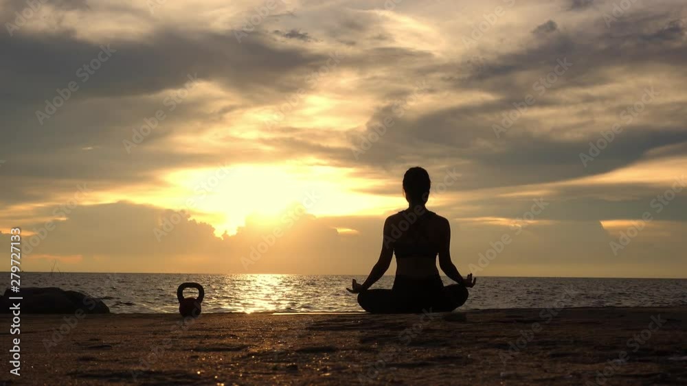 Full length rear view of the silhouette of a sporty while practicing yoga pose, shot at sunset during summer vacation video format 4k. health concept. Full length rear view of the silhouette of a sporty while practicing yoga pose, shot at sunset during summer vacation video format 4k. health concept.
