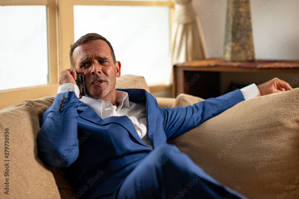 He flies into a rage. Businessman talking on a phone after work in office He flies into a rage. Businessman talking on a phone after work in office