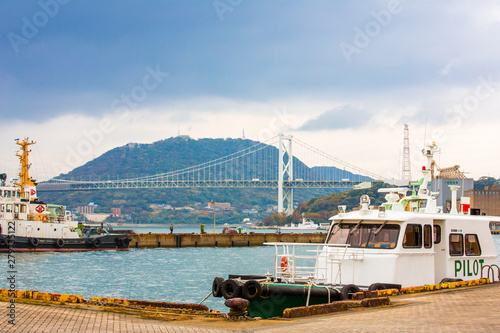 Kitakyushu, Japan - November 22, 2016 : Mojiko Port and Kanmonkyo Suspension Bridge in Kitakyushu, Japan. Kanmonkyo Suspension Bridge connecting Kyushu to Honshu. photo