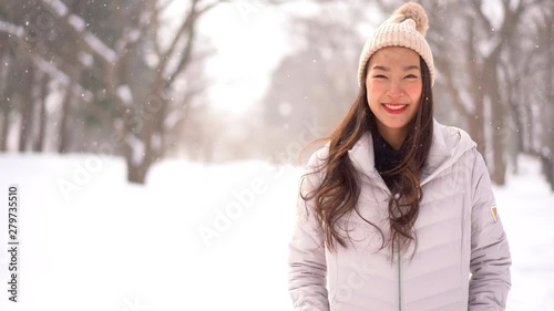 Woman smiles and looks towards camera during snowfall in Hokkaido photo