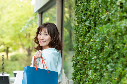 ショッピングバッグを持つ笑顔の女性