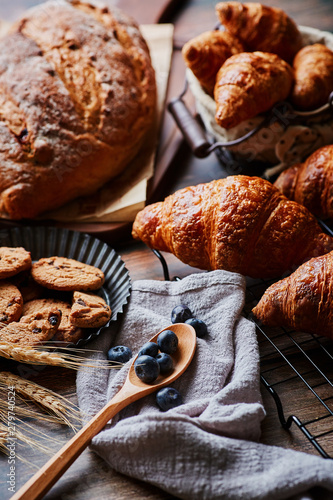 Delicious pastry and wheat spikes on the wooden table