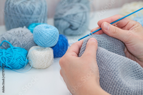 girl crochets, in the background there are balls of thread, Close-up