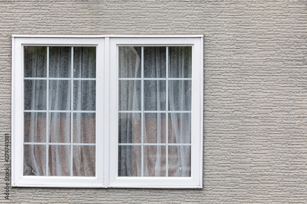Gray brick wall with white window. Modern residential window in brick wall Gray brick wall with white window. Modern residential window in brick wall