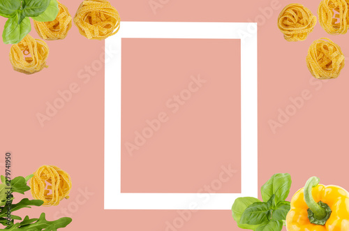 Top view of raw ingredients of taliatele pasta on creative coral background photo