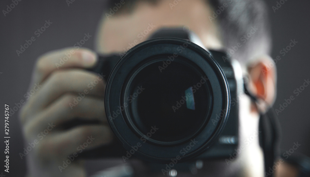 Professional photographer holding a DSLR camera.