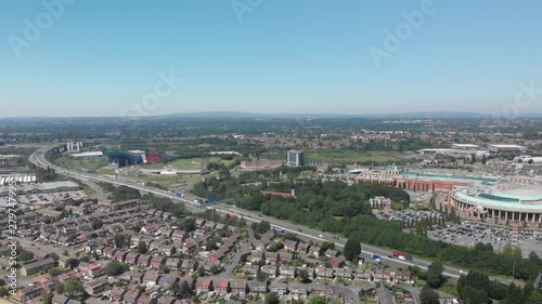 A shot panning left looking out over the motorway, Trafford Park and Manchester on a Summer day. You can see many of the houses in the area with Manchester skyline in the background.