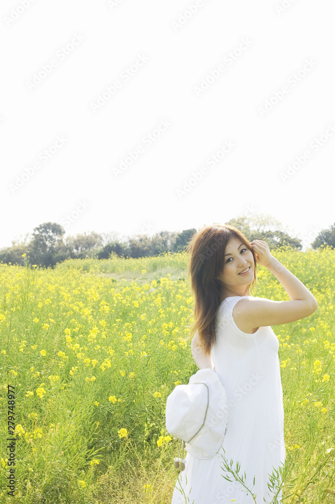 菜の花畑に立って振り返る女性 菜の花畑に立って振り返る女性