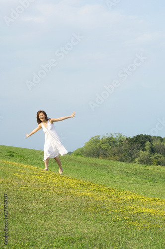 草原を走る笑顔の女性