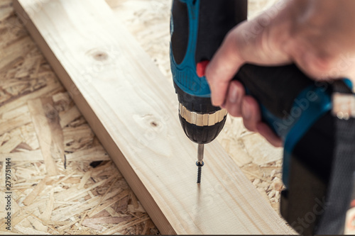 Girl the carpenter screwed a screw with a screwdriver