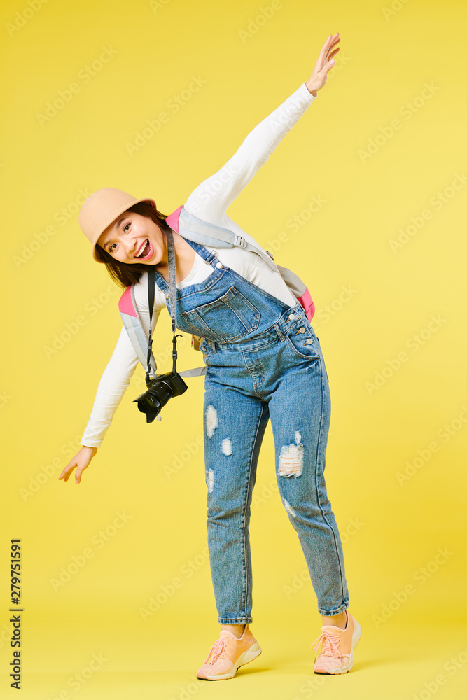 Fototapeta premium Happy excited female tourist with digital camera dreaming of flying by plane
