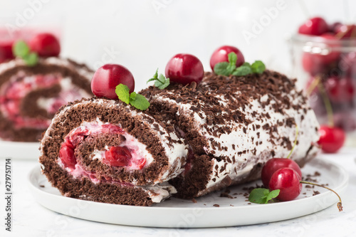Chocolate roll cake with cream and cherries. Summer dessert  with berries