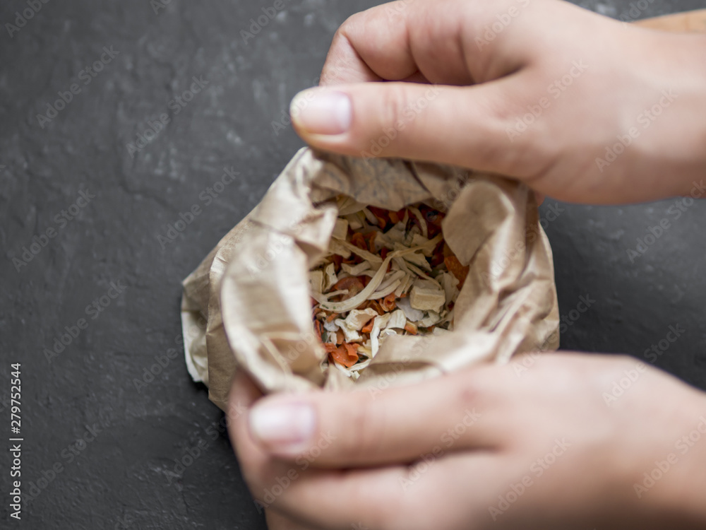Hands opening paper bag full of spices