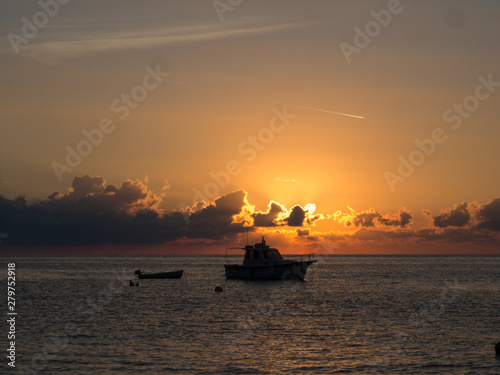 Sunrise and boat in mediterranean sea. Pantelleria Island, Italy
