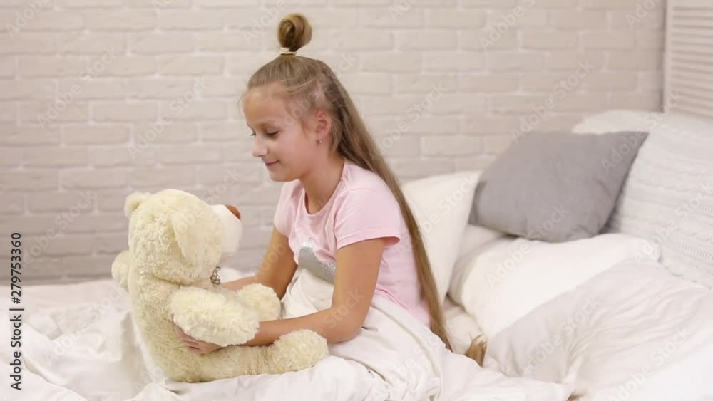 cute little child girl wakes up from sleep and hug teddy bear in bed in the morning cute little child girl wakes up from sleep and hug teddy bear in bed in the morning