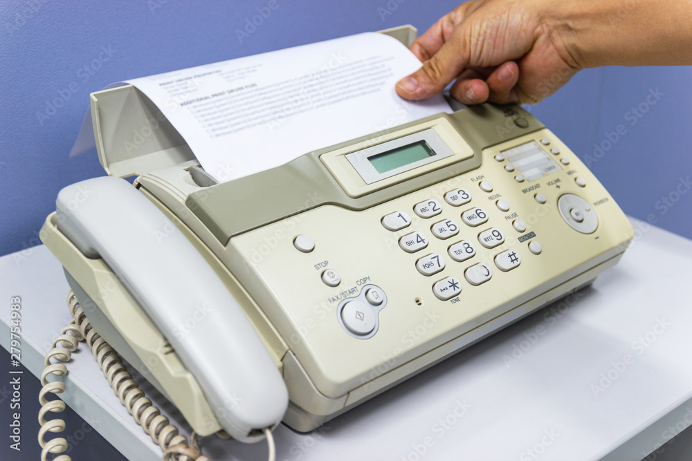 hand man are using a fax machine in the office hand man are using a fax machine in the office