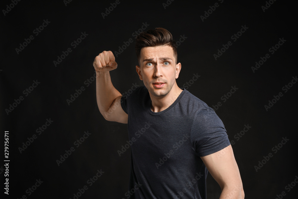 Aggressive young man on dark background