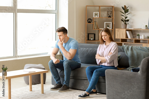 Obraz na płótnie Young offended couple after quarrel sitting on sofa at home