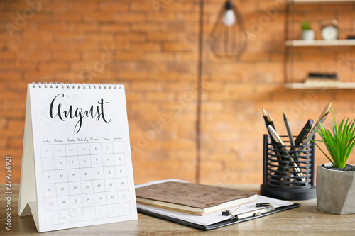 Flip paper calendar and stationery on office table photo