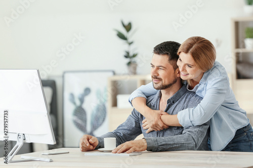 Happy couple in love using computer at home