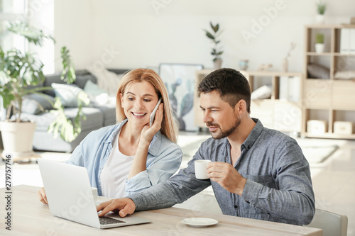 Happy couple in love using laptop at home