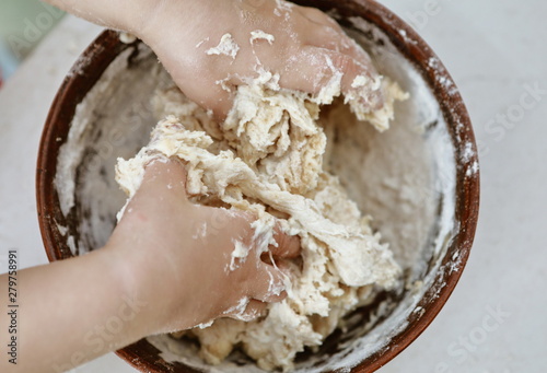 baby hands knead the dough in a pizza plate