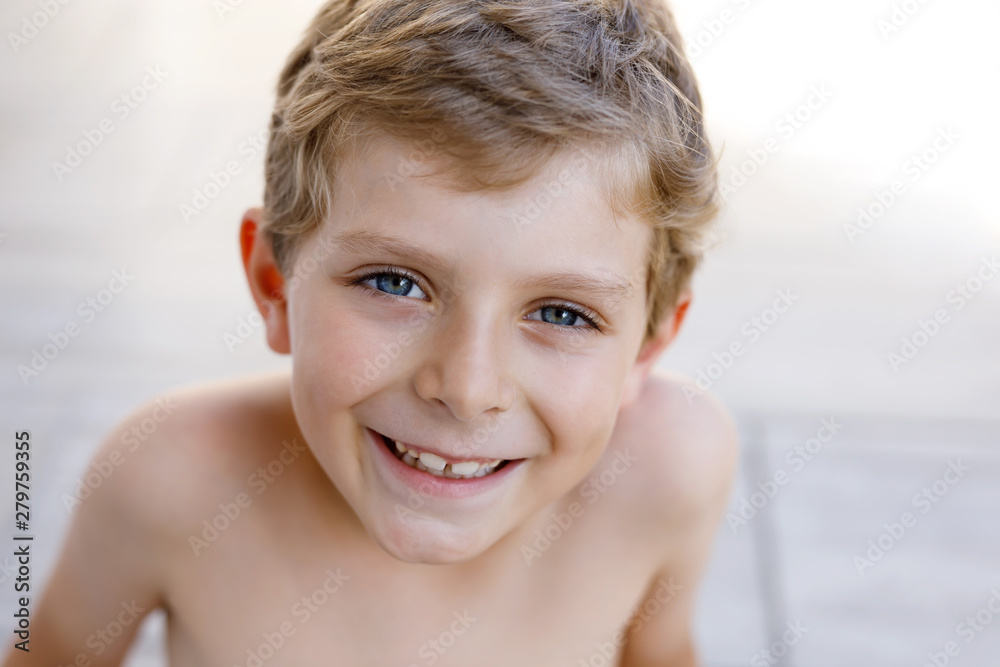 Beautiful Smiling Little Boy Portrait on warm sunny summer day. Happy kid looking at the camera. Adorable child with blond hairs and blue eyes Beautiful Smiling Little Boy Portrait on warm sunny summer day. Happy kid looking at the camera. Adorable child with blond hairs and blue eyes
