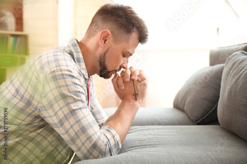 Religious man praying at home