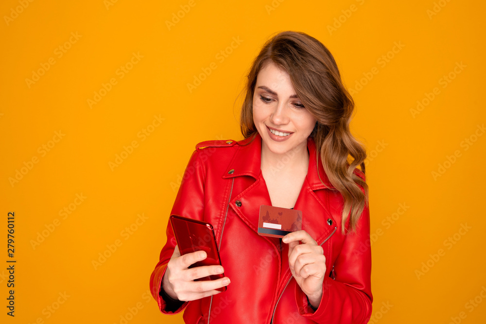 Handsome female person with credit card isolated over the yellow background Handsome female person with credit card isolated over the yellow background