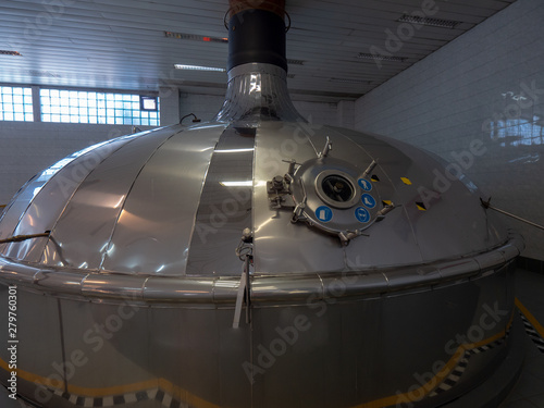 Equipment for preparation of beeer..Lines of metal tanks in modern brewery. Manufacturable process of brewage. Mode of beer production. Inside view of modern brewhouse with stainless barrels photo