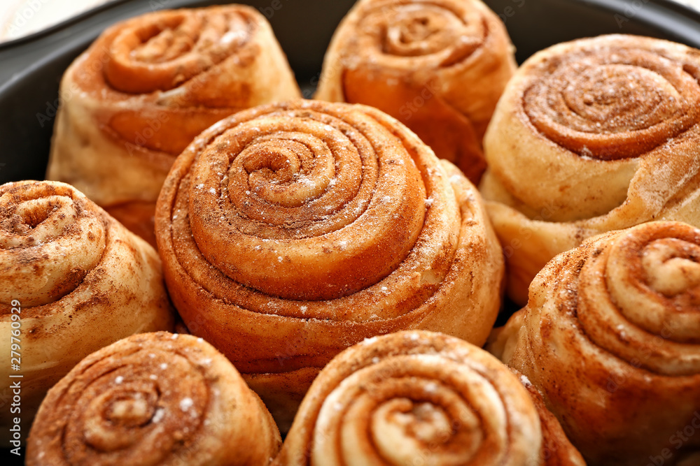 Tasty cinnamon buns in baking tray, closeup
