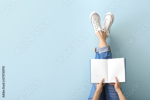 Woman with book on color background photo