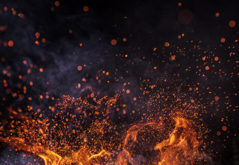 Burning sparks flying. Beautiful flames. Fiery orange glowing flying away particles on black background.