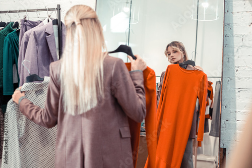 Blonde woman with long straight hair looking for dress