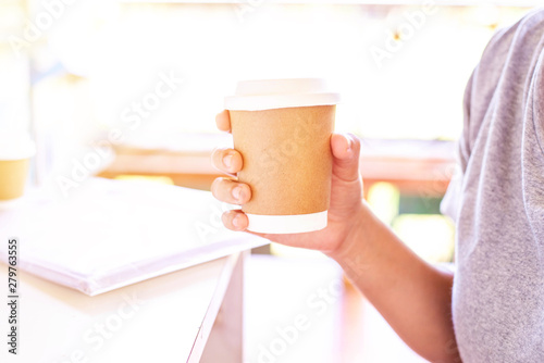 Fototapeta Naklejka Na Ścianę i Meble -  Hand holding hot coffee take away cup