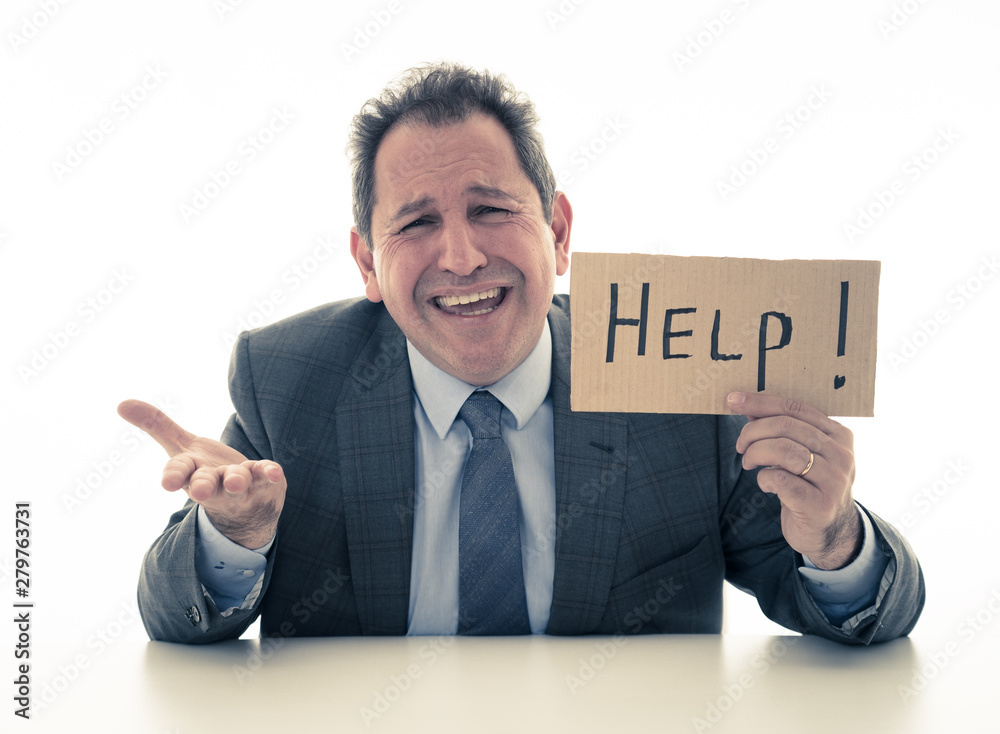 Attractive mature businessman overwhelmed and tired holding a help sign Attractive mature businessman overwhelmed and tired holding a help sign