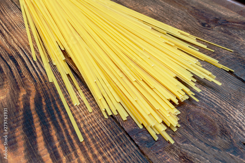 spaghetti, macaroni, pasta, linguine durum wheat Italian thin long on wooden background close up selective focus photo