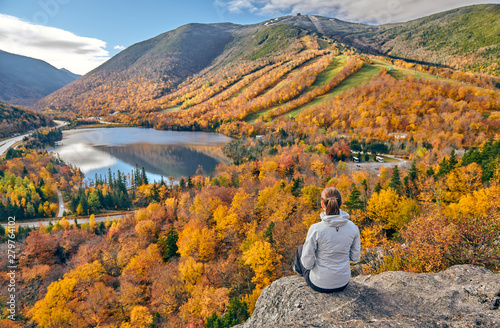 Obraz na płótnie Woman hiking at Artist's Bluff in autumn. View of Echo Lake. Fall colours in Franconia Notch State Park. White Mountain National Forest, New Hampshire, USA w salonie