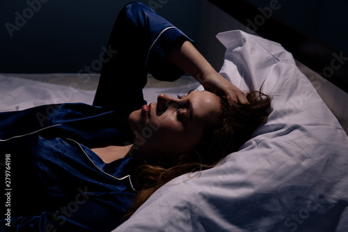 Upset woman lying in bed in sleepless photo