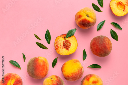 Fototapeta Naklejka Na Ścianę i Meble -  Flat lay composition with peaches. Ripe juicy peaches with green leaves on pink background. Flat lay, top view, copy space. Fresh organic fruit, vegan food. Harvest concept.