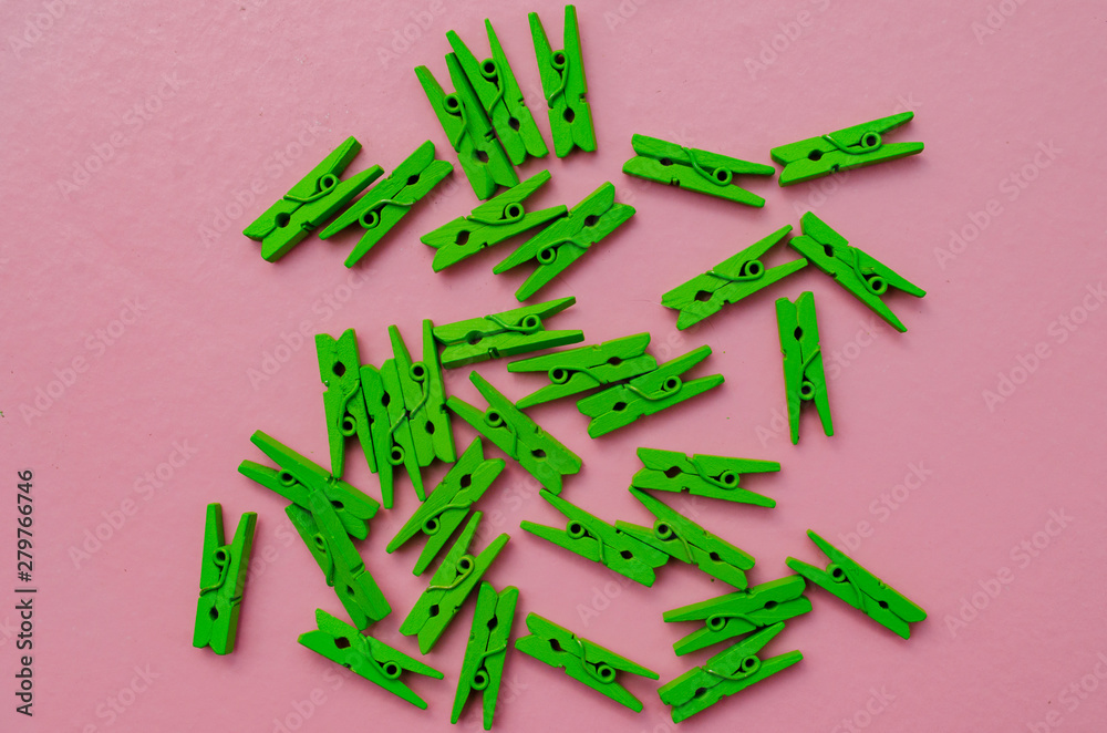 little green clothespins on a pink background